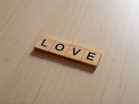 A close-up of wooden letters spellingLovecaptures the essence of warmth and affection in a minimalist workspace.の写真素材