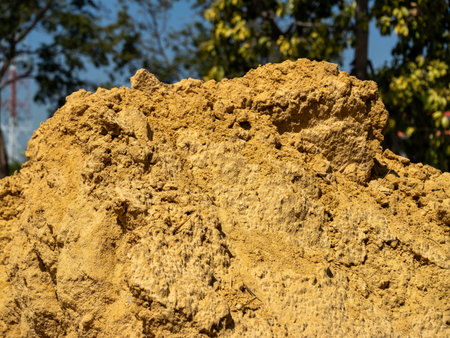 A close-up view of a yellow sand pile at a construction site highlighting its texture and color.の写真素材