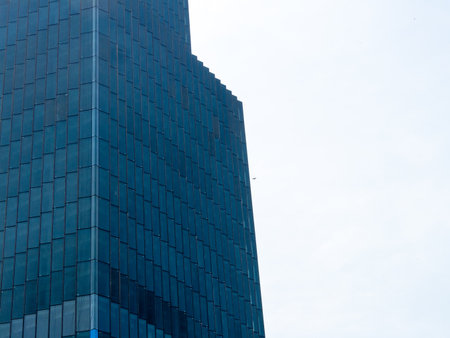 A striking image of a modern skyscraper reflecting the blue sky showcasing contemporary...