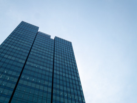 A stunning view of a modern skyscraper reaching towards the open sky showcasing contemporary architectural design.の写真素材