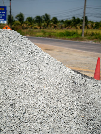 A gravel pile at a roadside quarry showcasing construction material delivery in an urban setting.の写真素材