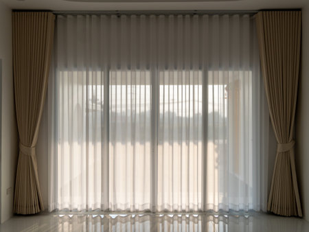 Sheer curtains enhance the ambiance of a modern living room with natural light filtering through.の写真素材