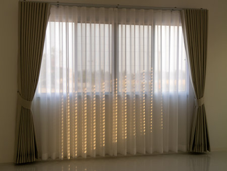 Sunlight filters softly through sheer curtains creating a serene ambiance in a contemporary living space.の写真素材