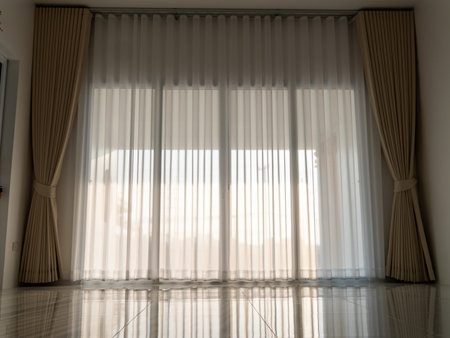 A serene view of sheer curtains enhancing the light in a modern room showcasing minimalist elegance.の写真素材