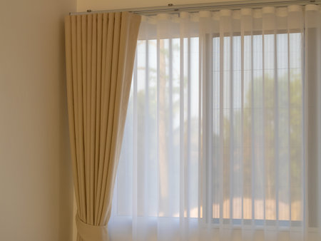 Elegant sheer curtains enhance the natural light in a modern living space creating a serene atmosphere.の写真素材