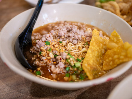 A vibrant bowl of noodle soup with savory toppings showcasing local flavors in a bustling market.