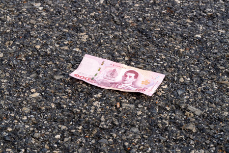 A solitary banknote lies abandoned the pavement symbolizing lost value.の写真素材