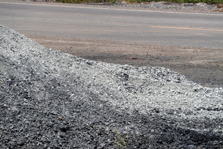 A gravel pile accumulates alongside a highway showcasing the ongoing construction process in an...