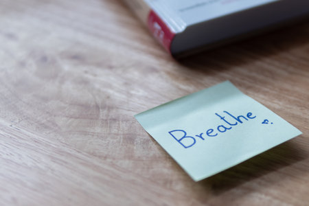 A simple note saying Breathe serves as a mindful reminder in a serene home office setting.の写真素材