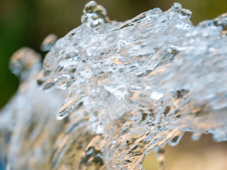 A close-up shot of water flowing gracefully in a serene nature park capturing the beauty of movement.の写真素材