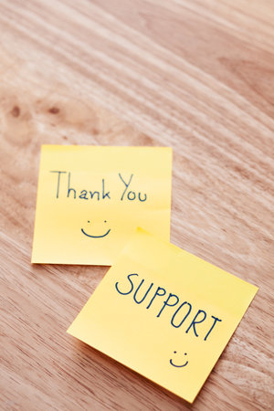 Bright yellow notes express gratitude and support emphasizing positivity in a cozy setting.の写真素材