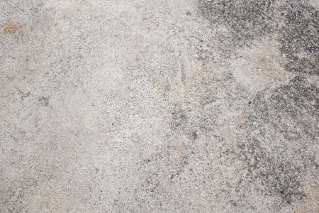 This image showcases a weathered concrete surface revealing intricate textures and patterns.の写真素材