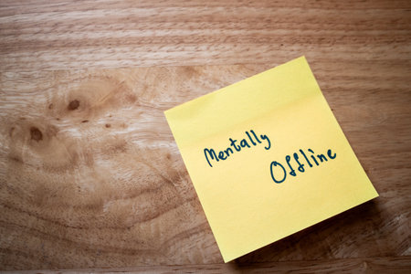 A sticky note readsMentally Offlinehighlighting the importance of mental health in our busy lives.の写真素材