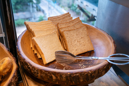 Experience the fresh aroma and texture of bread slices in a cozy urban bakery.の写真素材
