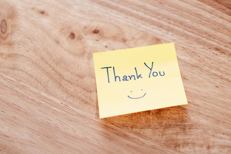 A simple thank you note a wooden surface symbolizing appreciation and warmth.