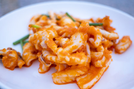 A vibrant close-up of a mouthwatering octopus dish served at a coastal restaurant.の写真素材