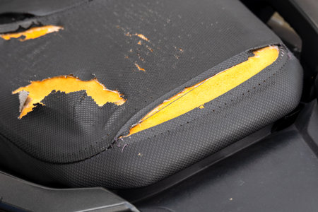 A close-up of a worn-out office chair cushion showcasing signs of heavy use and damage.の写真素材