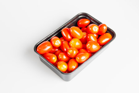 A vibrant arrangement of fresh cherry tomatoes a kitchen table emphasizing their delicious appeal.の写真素材