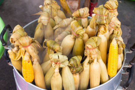 Fresh corn is steamed to perfection at a bustling local market showcasing vibrant colors and textures.の写真素材
