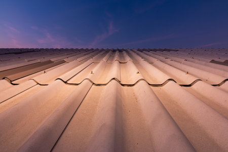 The image captures a close-up of a rooftop showcasing the installation process at dusk in an urban environment.の写真素材