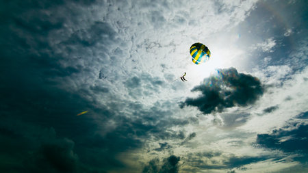 A paraglider soars through a dramatic sky capturing the thrill of adventure along the coast.の写真素材