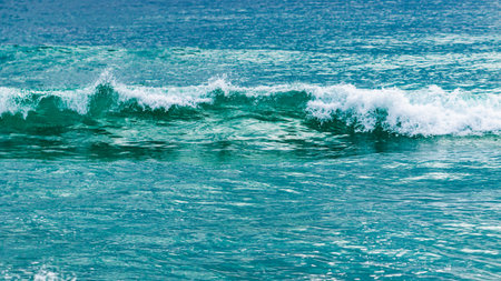 Explore the dynamic beauty of ocean waves crashing a tranquil beach capturing nature's power.の写真素材