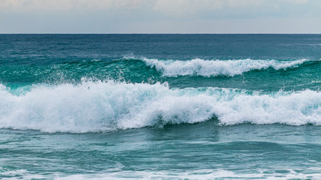 Experience the serene beauty of crashing waves at a tranquil ocean beach.の写真素材