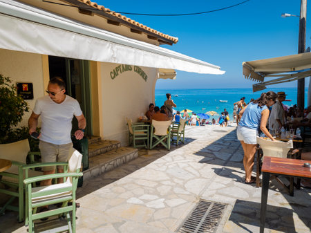Lefkada. Greece. 07.18.2020. Tourists on Summer vacation relaxing in the village of Agios Nikitas. A beautiful and popular Greek island holiday destination.のeditorial素材