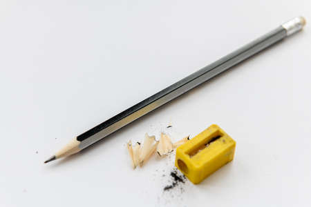 A sharpened pencil with shavings isolated with a white background.
