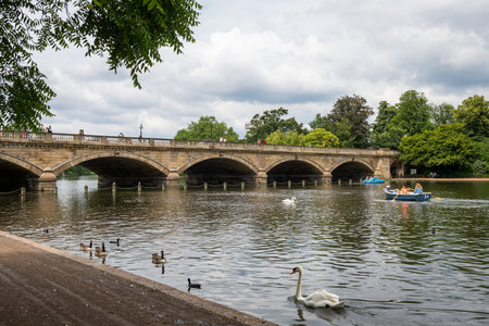 London. UK- 07.11.2021. The Serpentine Bridge in Hyde Park with visitors enjoying boating on the lake.のeditorial素材