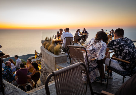 Lefkada island. Greece- 08.07.2021: people and tourists enjoying fine dining in a hill top...