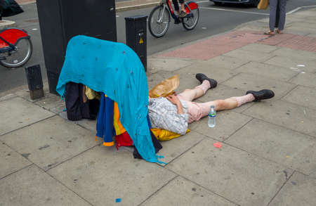 A homeless beggar sleeping on the street.の写真素材