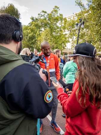 London. UK. 10.03.2021. A news crew interviewing an athlete in Pall Mall at the end of the London Marathon.のeditorial素材