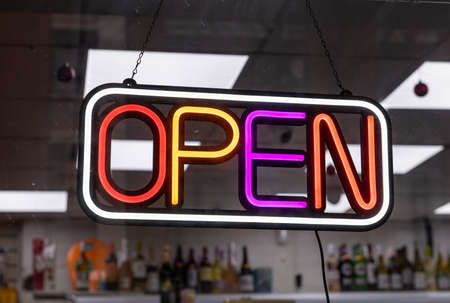 A neon open sign in a shop window.の写真素材