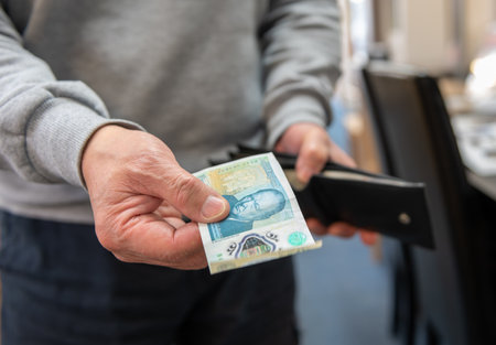A customer paying with a bank note in a retail store. Inflation, cost of living concept.