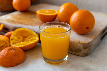 A home made freshly squeezed glass of orange juice on work top.の写真素材