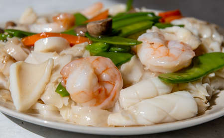 A dish of stir fried seafood with rice pasta or Ho Fun with sauce.の写真素材