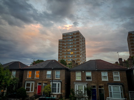 London. UK-05.17.2022. Semi detached houses and a local council social housing block of flats in a typical suburb of the capital with cloudy sunset sky.のeditorial素材