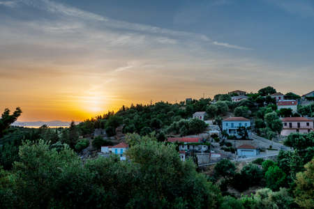 A beautiful sunrise over Kioni village on the hillside. Ithaca Island, Greece.の写真素材