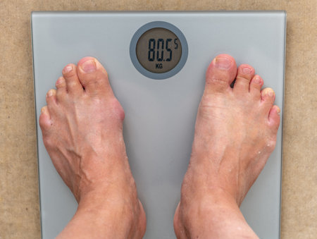 A person standing on a scale measuring body weight.の写真素材