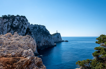 Distance view of a lighthouse built on a cliff top on the cape of an island.の写真素材