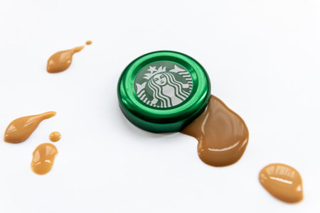 London. UK. 11.30.2022. A Starbuck Coffee bottle cap with drops of coffee isolated in white.のeditorial素材