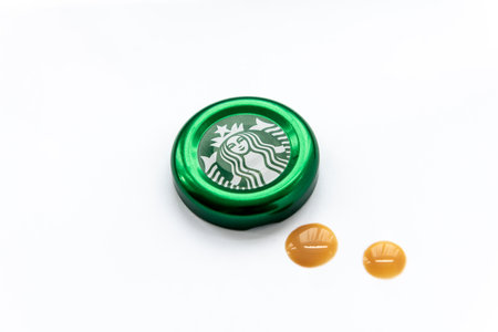 London. UK. 11.30.2022. A Starbuck Coffee bottle cap with drops of coffee isolated in white.のeditorial素材