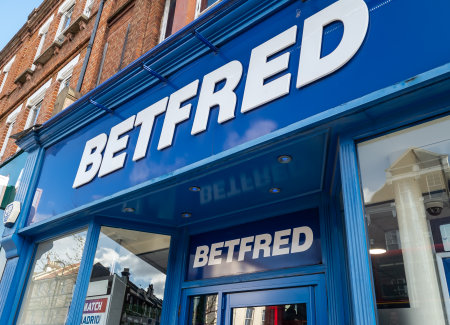 London. UK- 04.12.2023. The company name sign above the entrance of a retail branch of Betfred book maker, betting shop.のeditorial素材