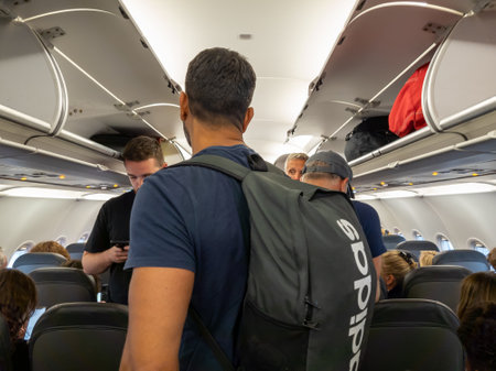 Gatwick airport. UK-06.23.2023. Arriving passengers on a plane getting their cabin bags waiting to get off.のeditorial素材