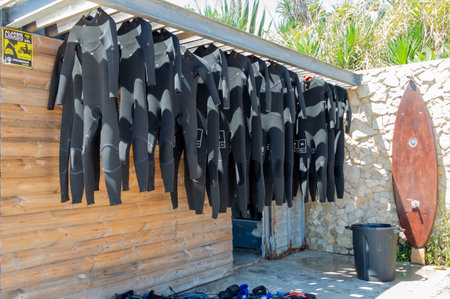 Lisbon. Portugal- 07.08.2023. Wetsuits and surfboards for rent to surfers at Carcavelos Beach.のeditorial素材