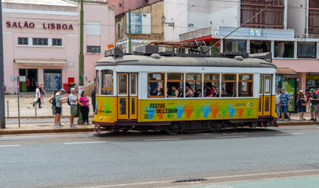 Lisbon. Portugal- 07.08.2023. Passengers and tourists getting on  and off a tram car at a tram stop.のeditorial素材