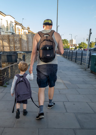 London. UK- 08.10.2023. A father and son holding hands walking on the street.のeditorial素材