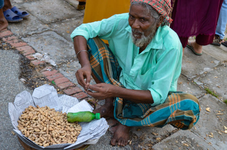 Rajshahi. Bangladesh- 08.15.2023. A man selling peanuts by the roadside.のeditorial素材