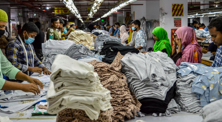 Narayanganj. Bangladesh- 08.23.2023. Interior of a knitwear factory with staffs working in the production line.のeditorial素材